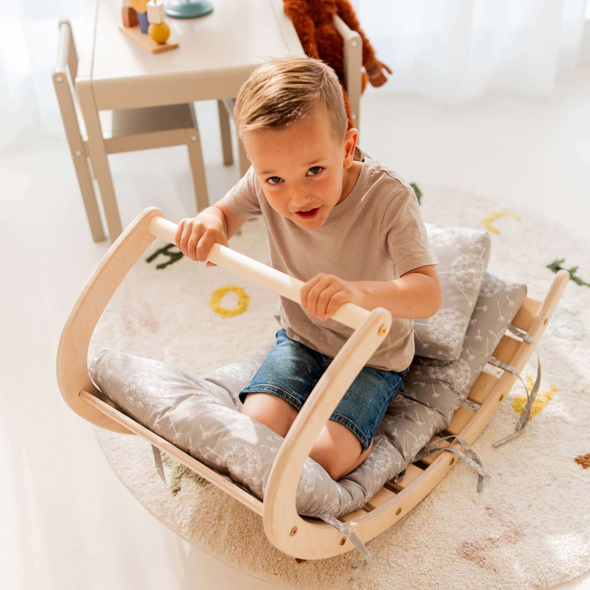 Kletterset Äffchen: Junge mit Holz-Kletterbogen, übt Klettern auf bequemen Polstern, fröhliche Spielumgebung.