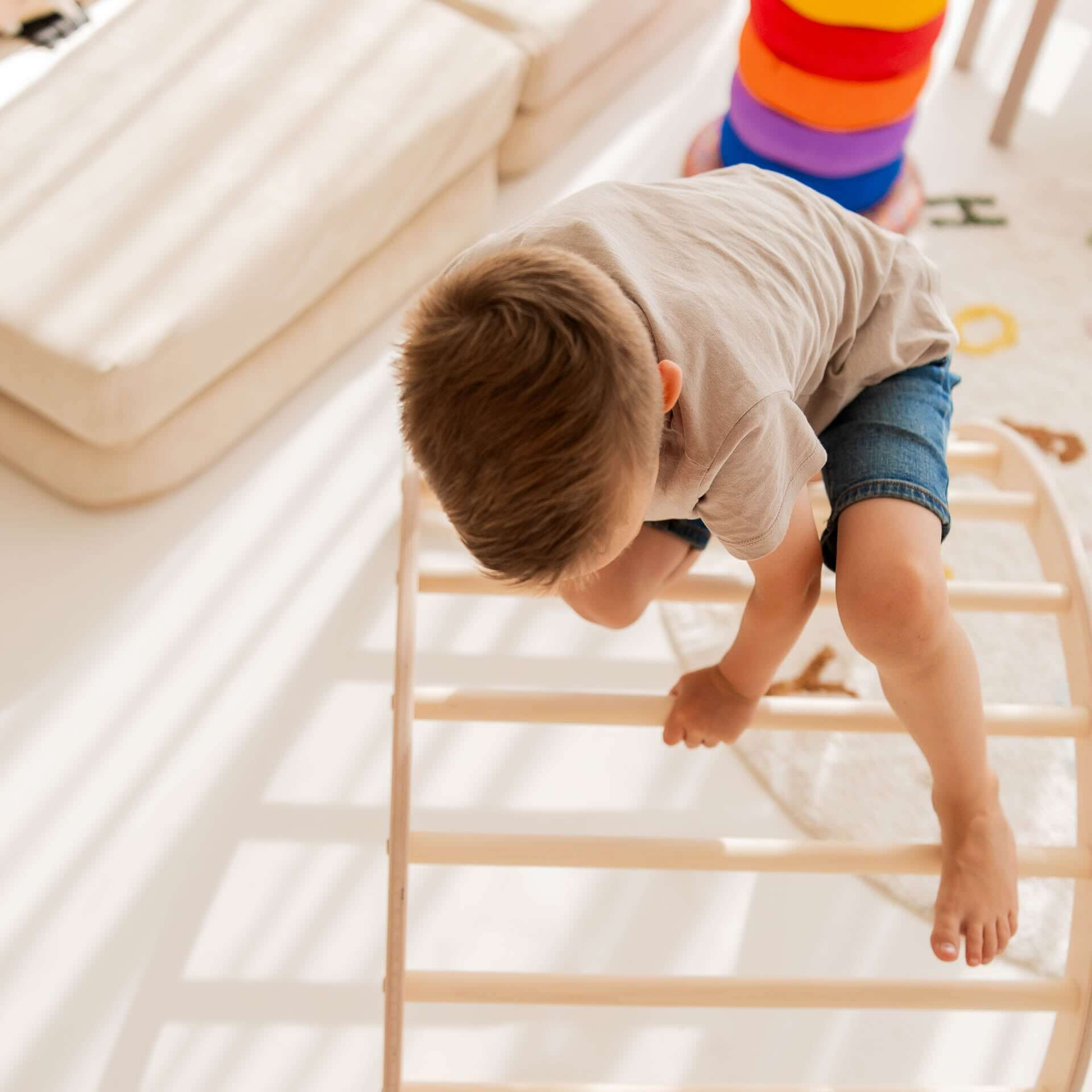 Kleine Kinderkletterbogen aus Holz, kind beim Klettern und Spielen, fördert Bewegungsfähigkeiten.