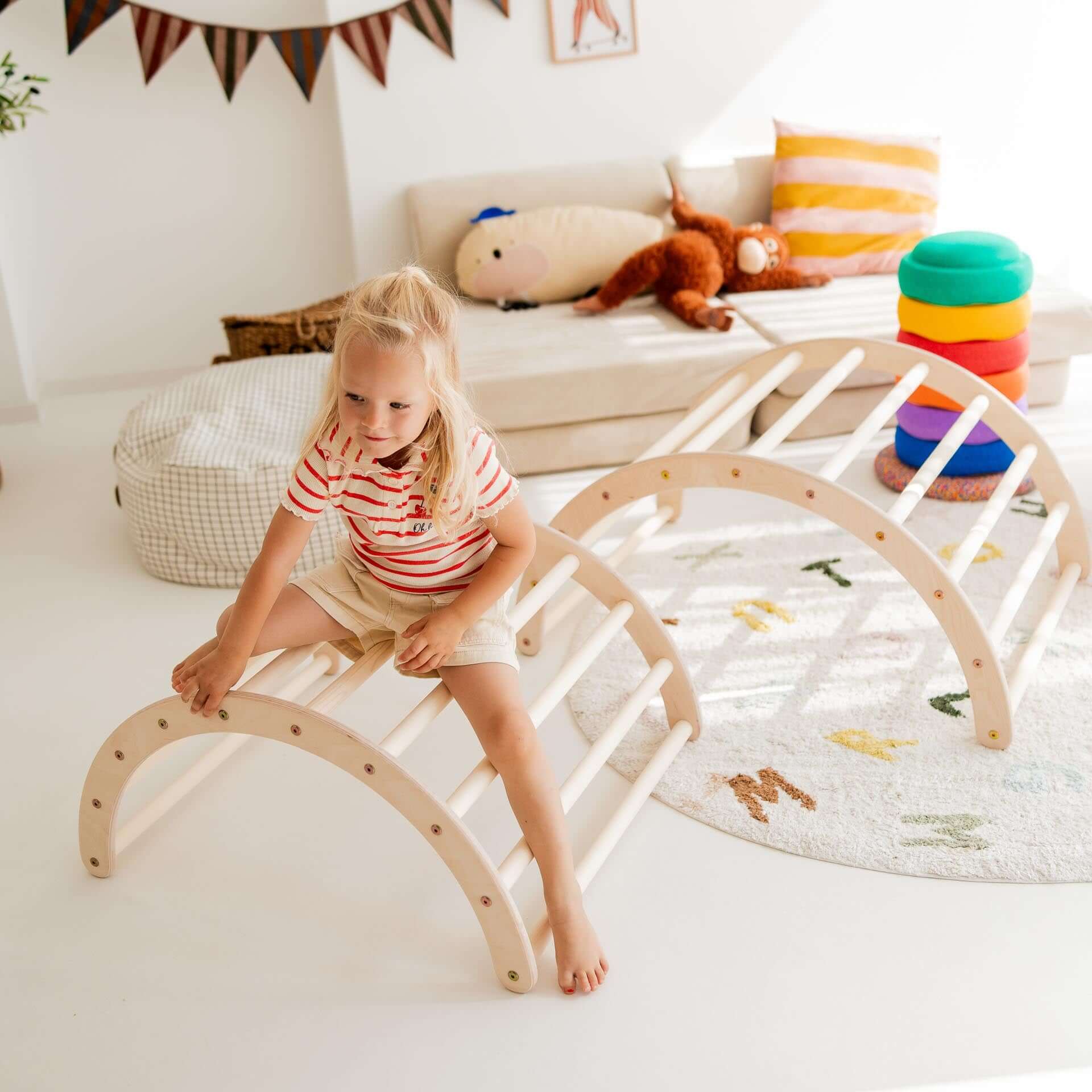 Ein Mädchen spielt auf einem Kletterbogen aus Holz, ideal für Kinder in verschiedenen Größen und Altersgruppen.