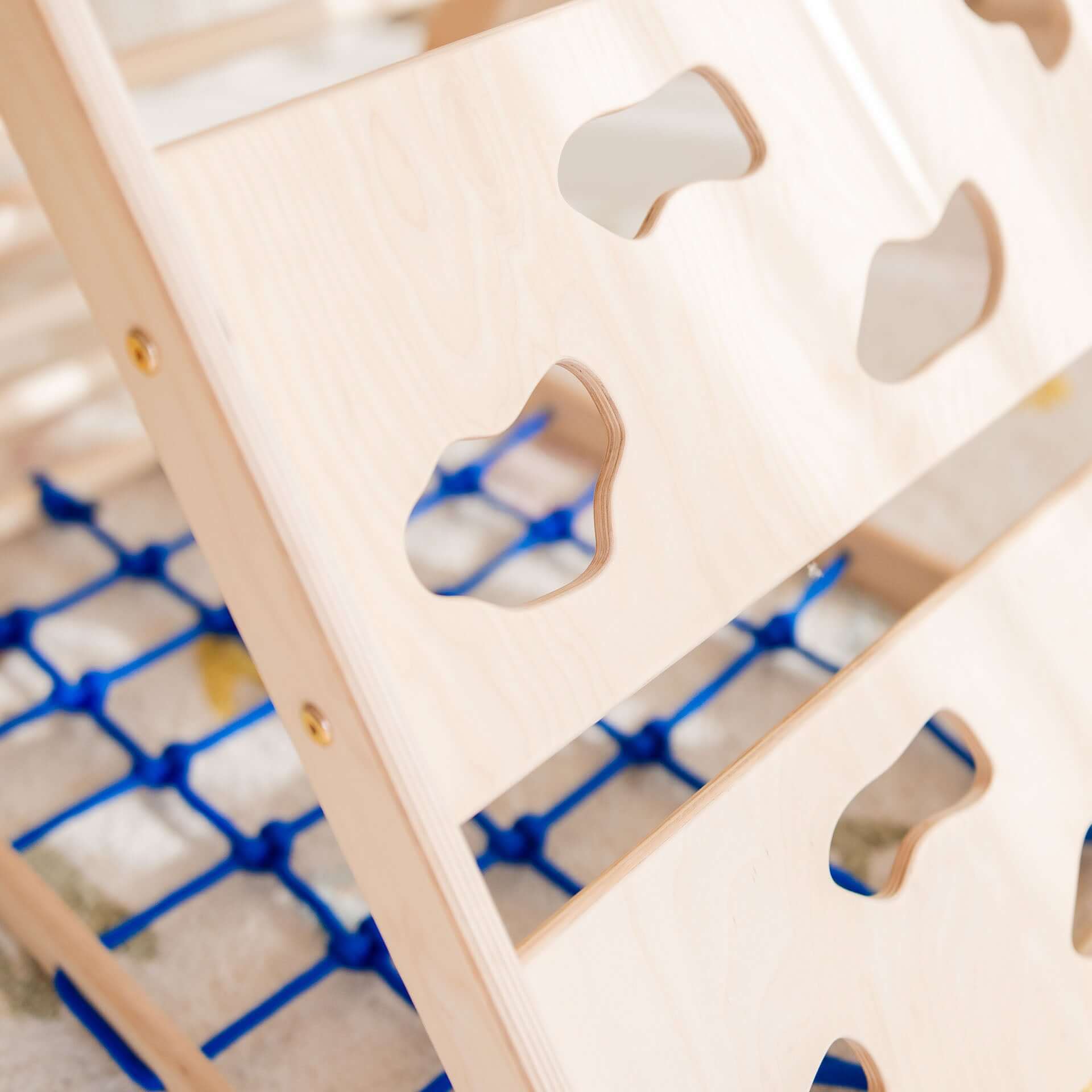 Detailansicht des Kletterdreiecks aus Holz mit Griffen und blauer Netzunterlage für Kletterset Äffchen.
