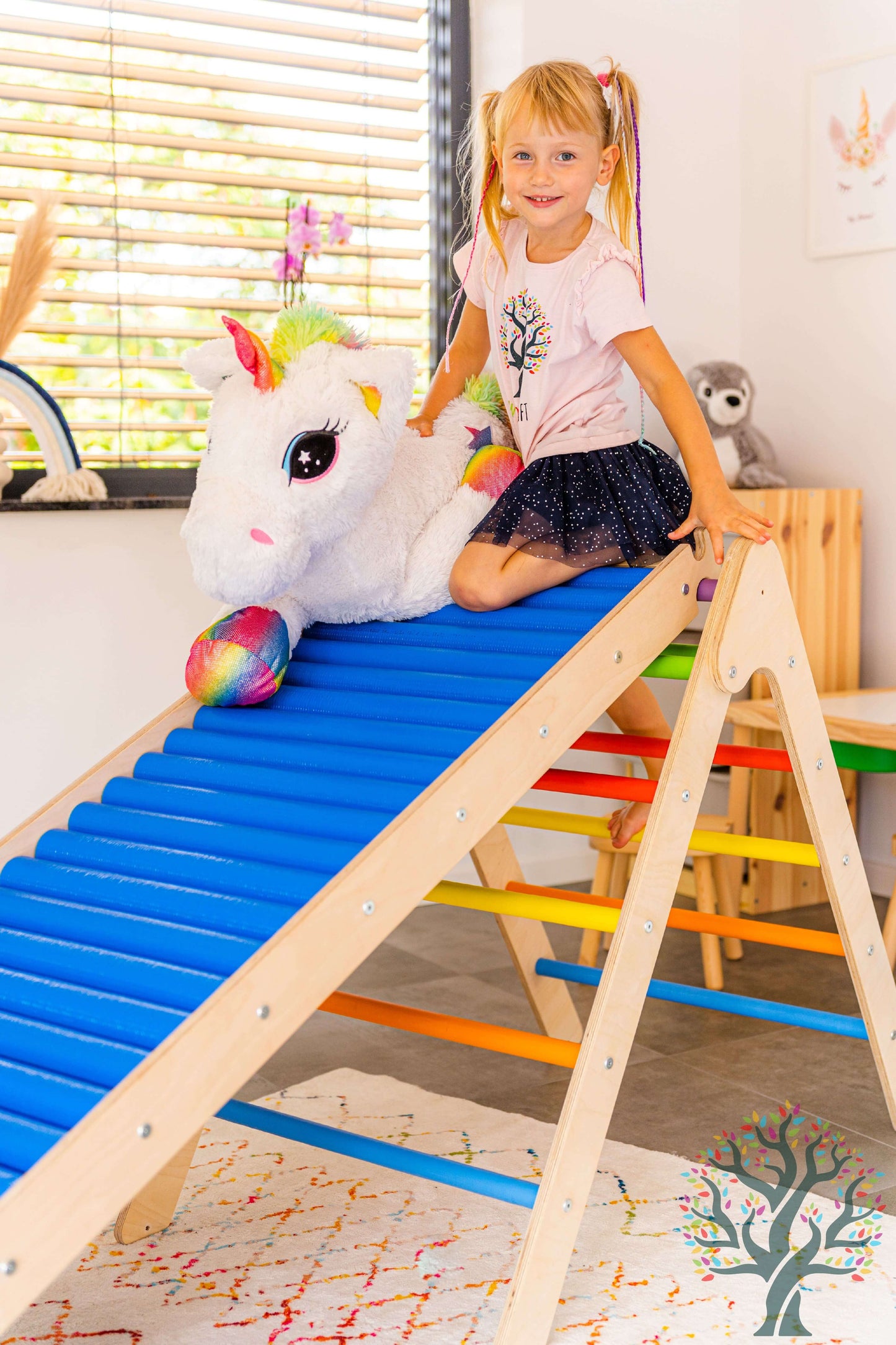 Mädchen auf der Rollenrutsche für Kinder, versch. Größen, mit einhornförmigem Spielzeug.