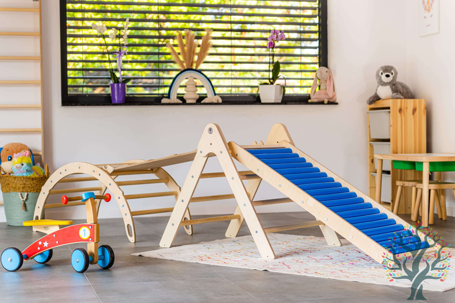 Rollenrutsche für Kinder, versch. Größen neben Kletterdreieck im Spielzimmer mit buntem Zubehör.