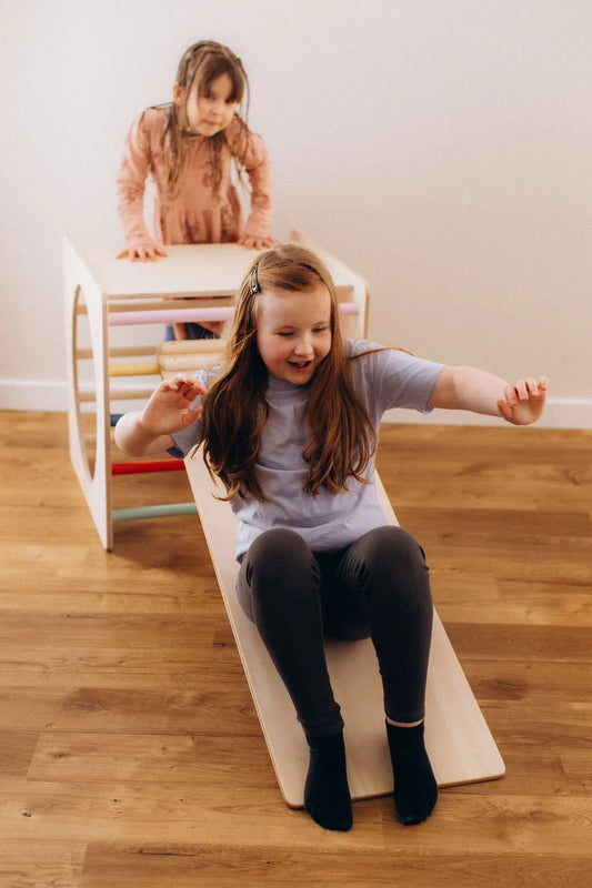 Zwei Kinder spielen mit einem Kletterwürfel versch. Farben und einer Rutsche, um ihre motorischen Fähigkeiten zu entwickeln.