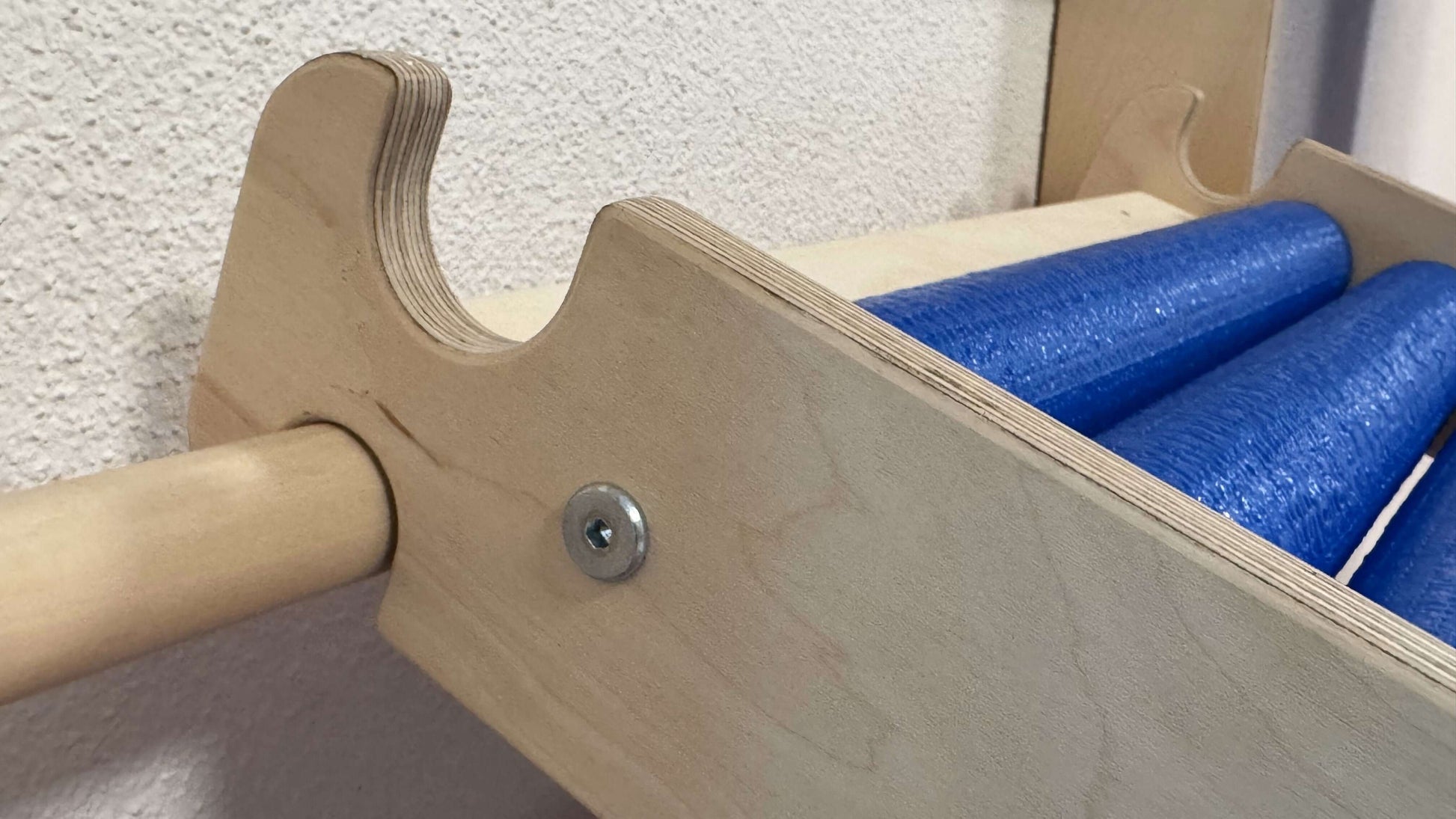 Detailansicht einer Rollenrutsche für Kinder, versch. Größen mit blauen Rollen und Holzrahmen.