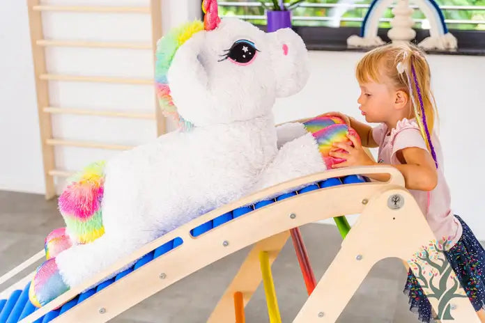 Wellen Rollenrutsche für Kinder mit einem weißen Plüsch-Einhorn und einem kleinen Kind, das spielt.