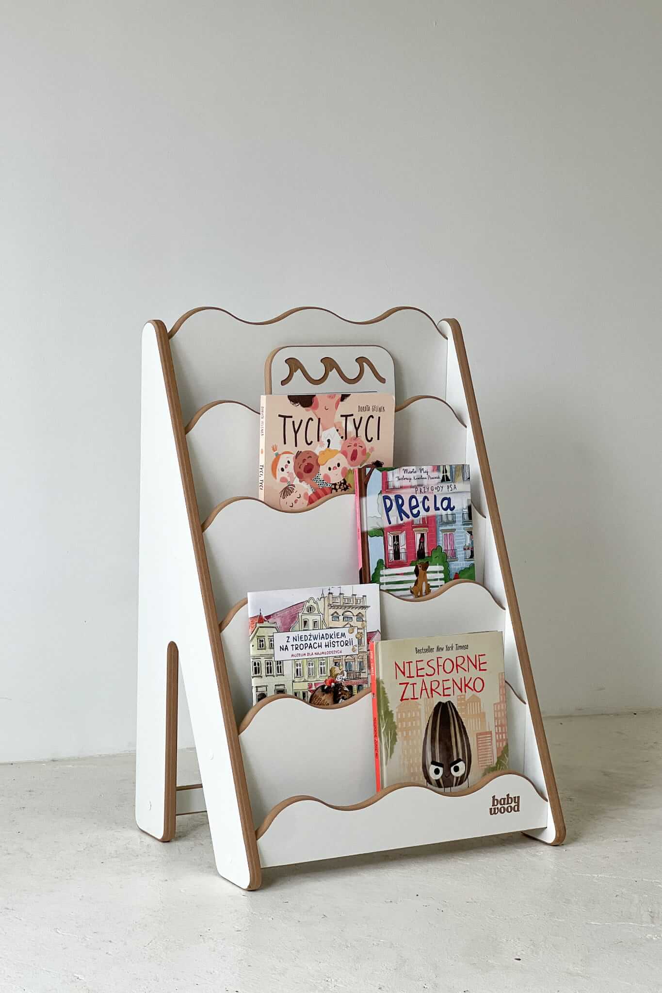 Bücherregal 'WAVE' aus Holz für Kinder mit bunten Büchern, ideal zur Präsentation von Geschichten.
