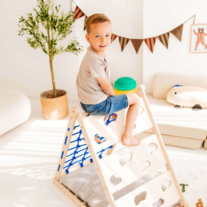 Junge auf Kletterdreieck Äffchen mit Sprossen und Netz in hellen Wohnraum, ideal für Kinderbewegung.