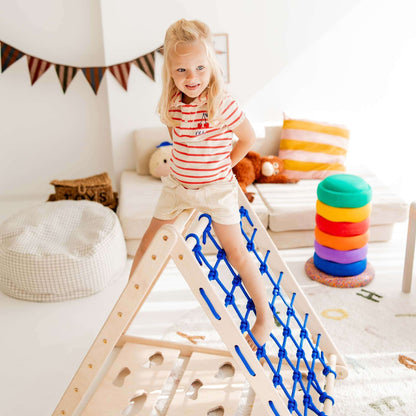 Ein Kind klettert fröhlich auf einem Kletterdreieck Äffchen mit Sprossen und Netz im Spielzimmer.